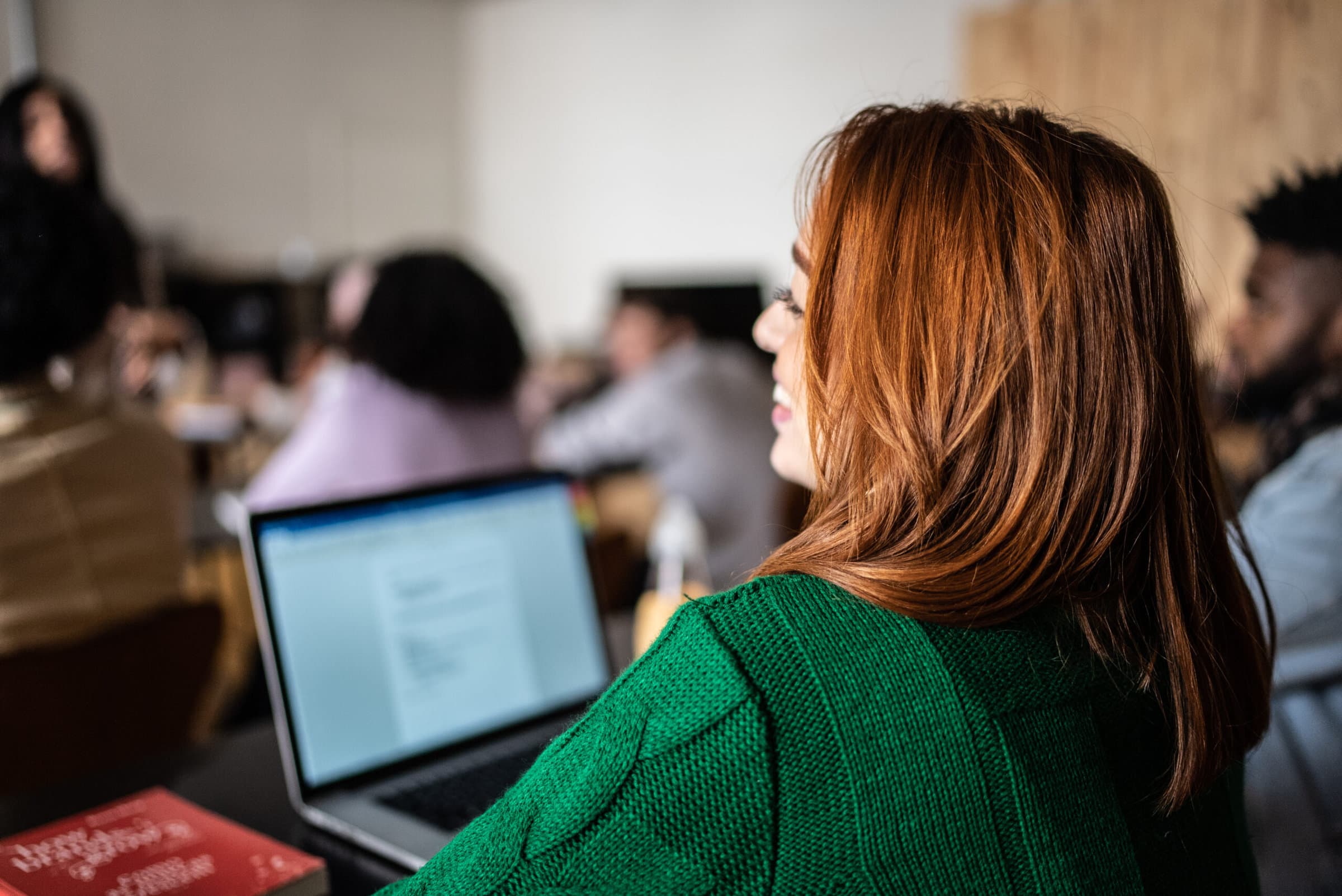 A woman working at a laptop in a classroom