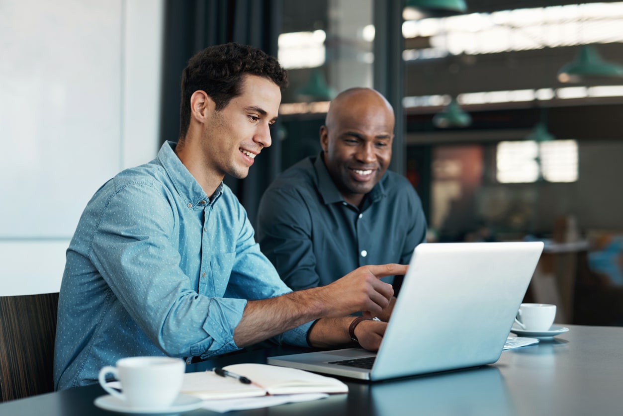 Teamwork, diversity and sales manager planning branding ideas with a creative designer on a laptop in an office. Logo, collaboration and businessman talking to an employee about a development project